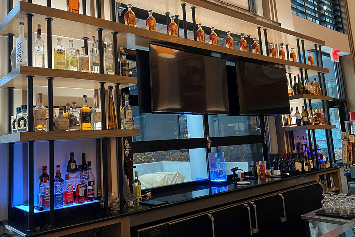 back bar with white oak-stained shelves and black pipe rail